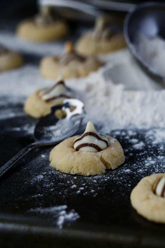 Hershey's Kisses Shortbread Cookies on black table with spoon and poured flour