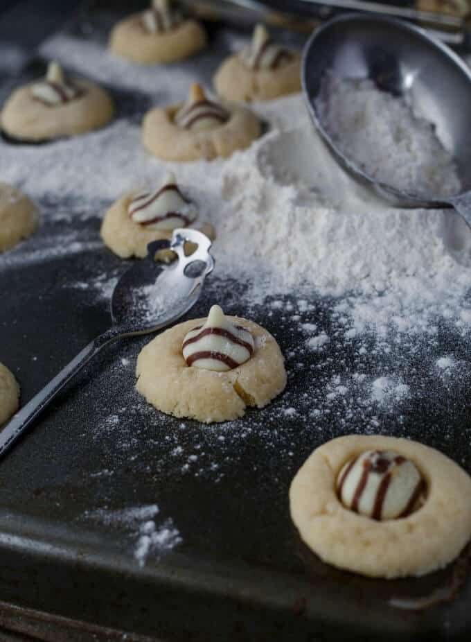 Hershey's Kisses Shortbread Cookies with spoon and white flour on black table