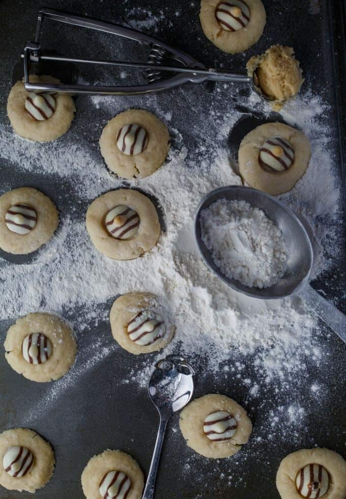 Hershey's Kisses Shortbread Cookies with spoon and flour on black table