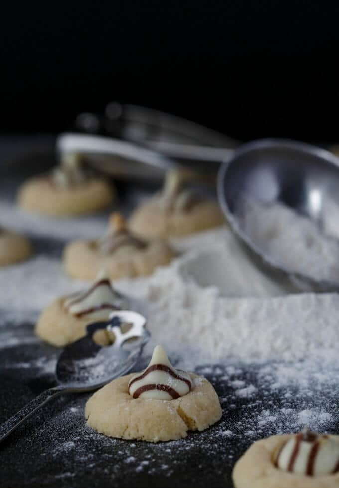 Hershey's Kisses Shortbread Cookies with spoon and flour on black table