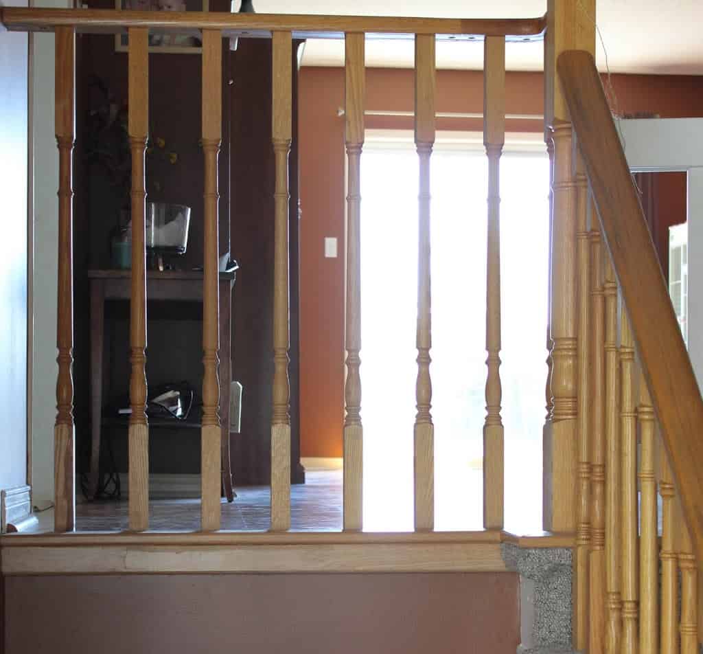 Brown wooden railing, window in the background