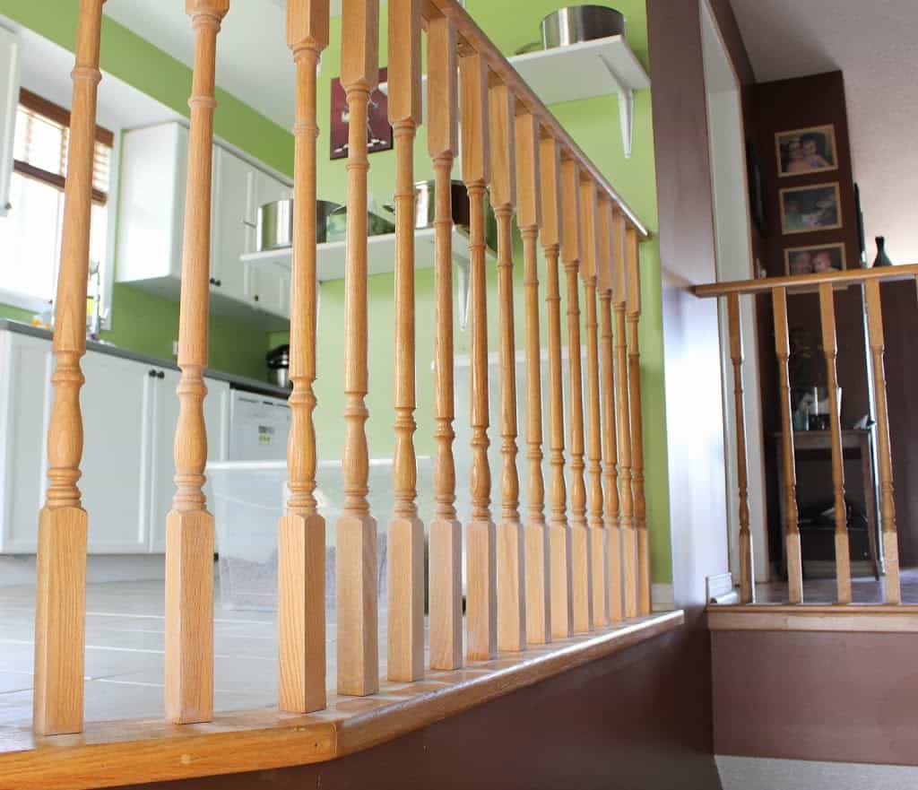 Brown wooden railing,kitchen with window in the background