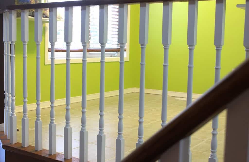 White and brown railings, windows and green walls in the background