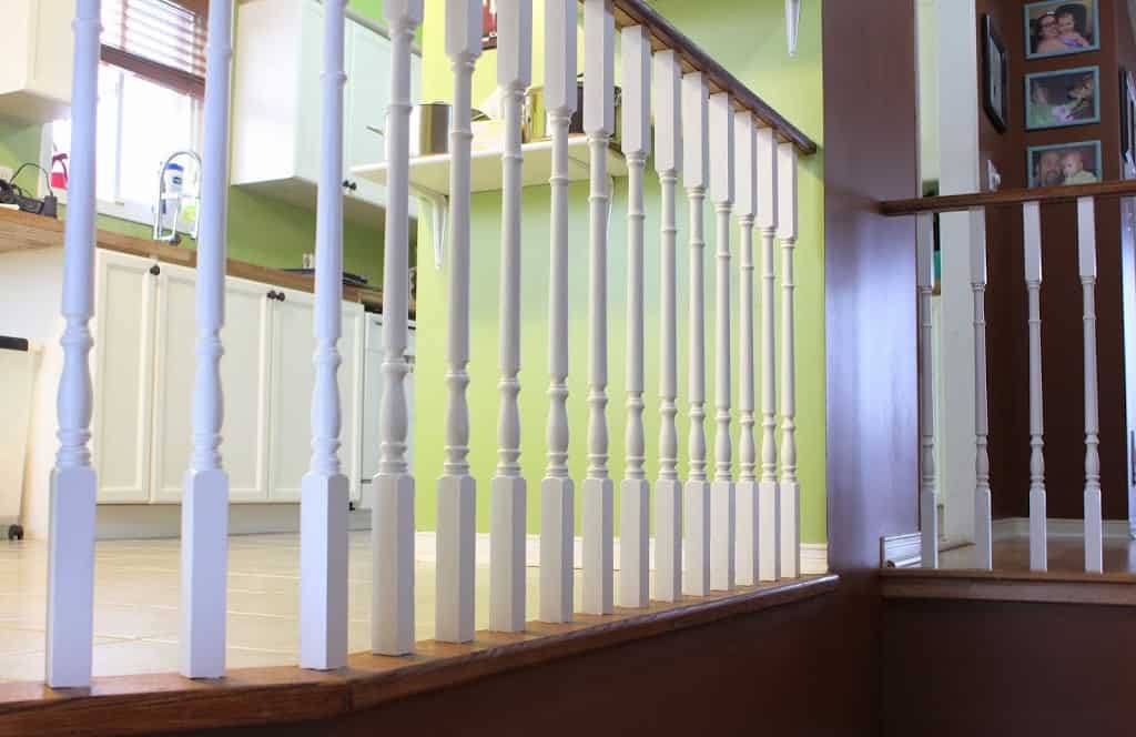 White and brown railings, kitcher furniture, window and green wall in the background