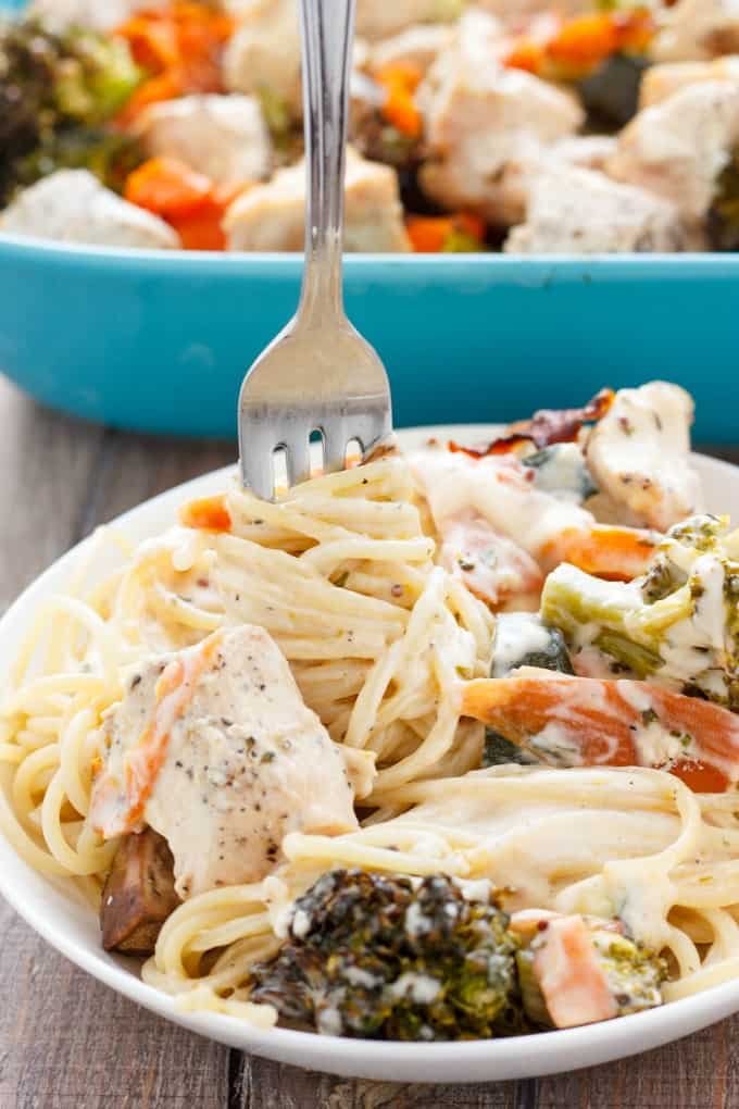 Chicken Fettuccine Alfredo with Veggies  on white plate with fork on table, bowl in background#pasta