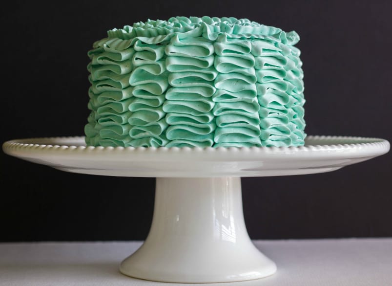 Green cake on white stray, black background