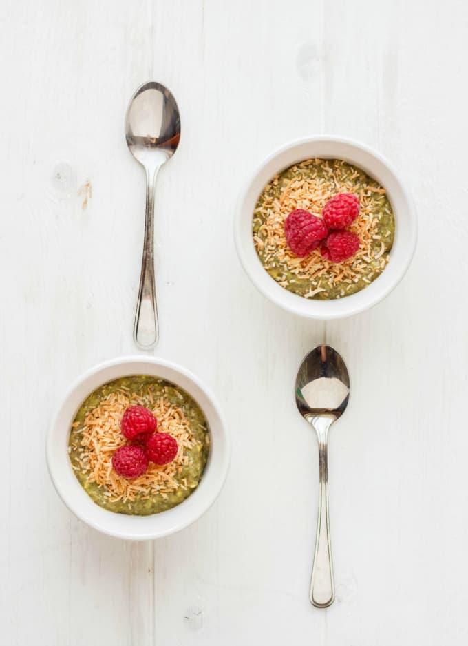 Vegan Green Tea Chia Seed Pudding in white bowls with raspberries and table spoons