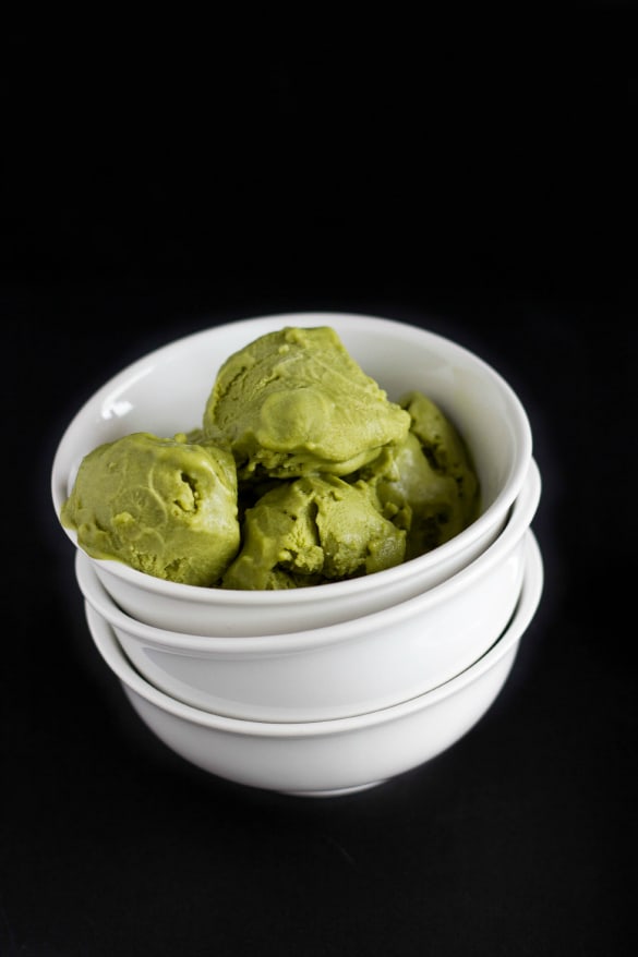 Vegan green tea ice cream in white bowl on black background