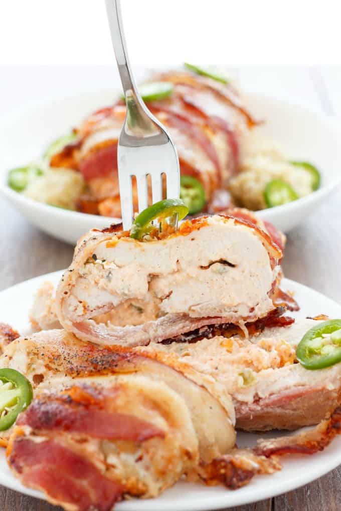 Jalapeno Popper Stuffed Chicken on white plate picked by fork, same dish  in the bowl in the background