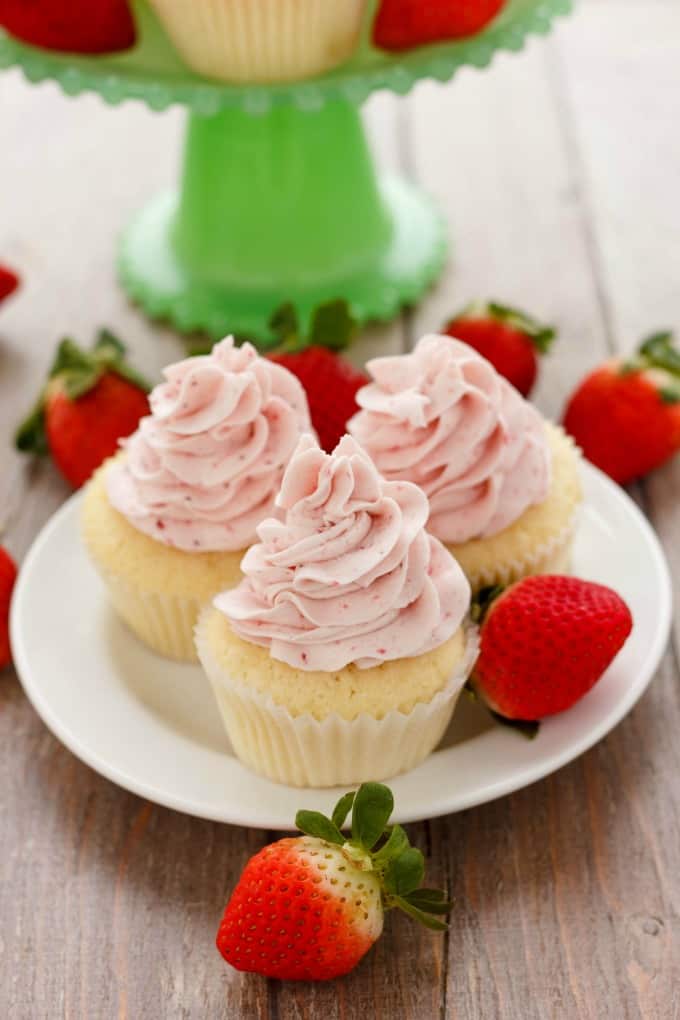 Lemon Cupcakes with Strawberry Swiss Meringue Buttercream on white plate and ripe strawberries#lemon