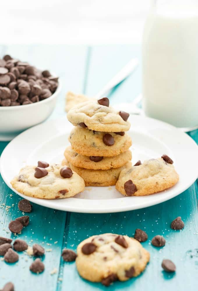 Soft and Chewy Chocolate Chip Cookies on white plate on blue table with chocolate chips and cookie#cookies