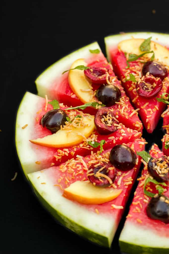 Healthy Vegan Watermelon Pizza Dessert sliced on black background