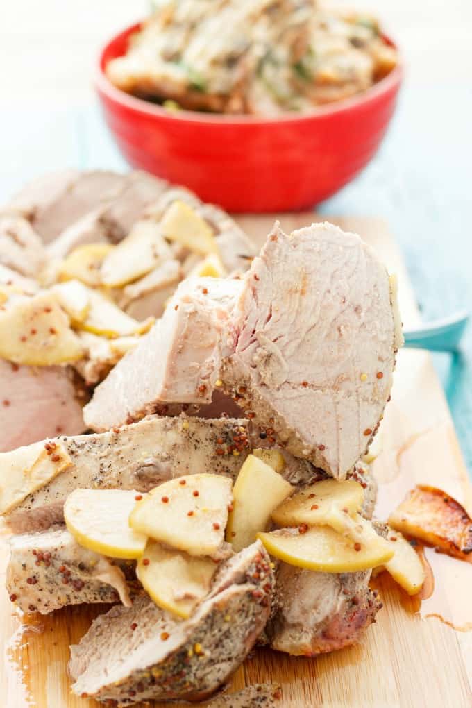 Pork Tenderloin in the Slow Cooker  on wooden kitchen pad sliced with red bowl in the background#pork