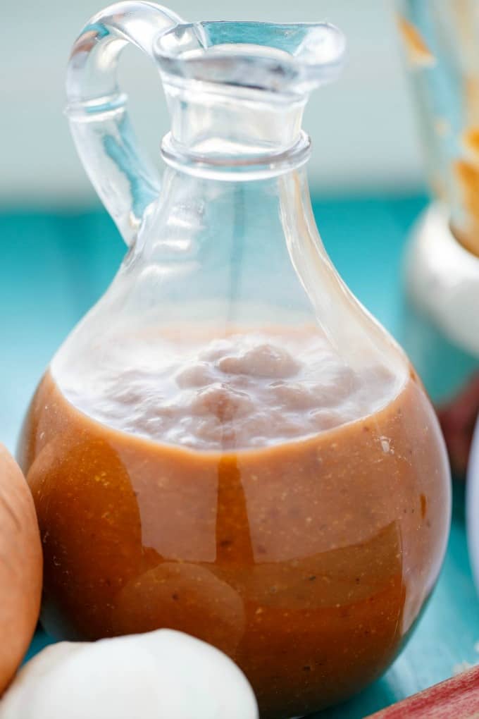 Rhubarb BBQ Sauce in glass jar on blue table next to veggies#BBQ