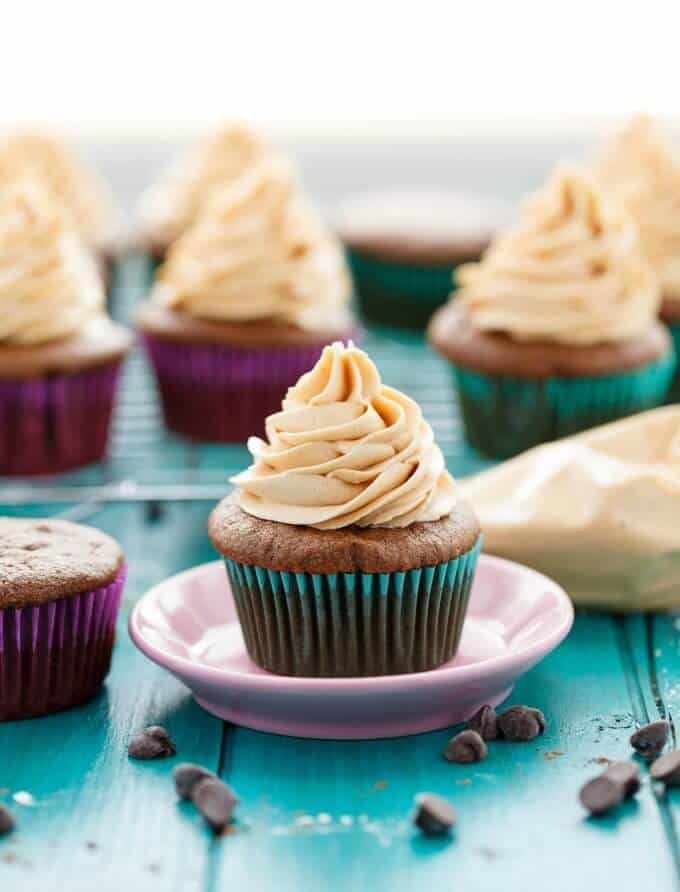 Gluten-Free Chocolate Cupcakes with Peanut Butter Frosting  on pink plate on blue table, cupcakes in the background#glutenfree