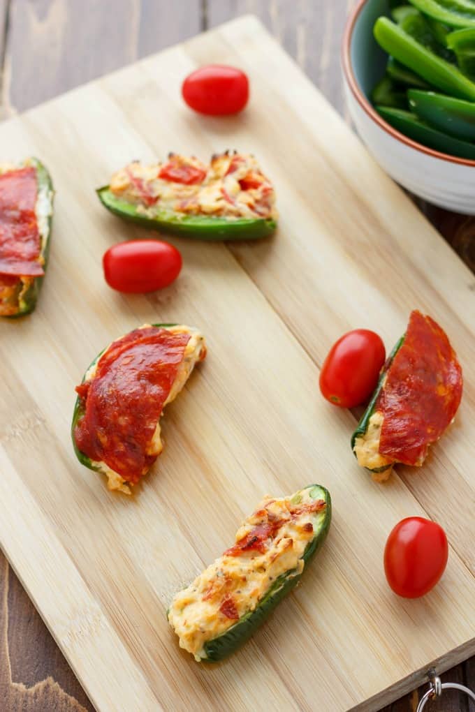 Pizza Stuffed Jalapenos on wooden kitchen pad with tomatoes #pizza