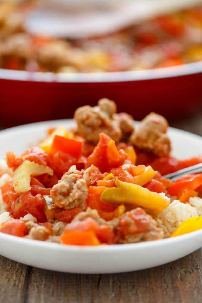 Sausage and Peppers over Rice on white plate in brown table#sausage