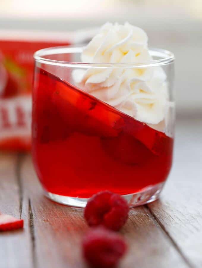 Strawberry and Raspberry Jell-O Parfaits with Almond Whipped Cream in glass with raspberries on table #nobake