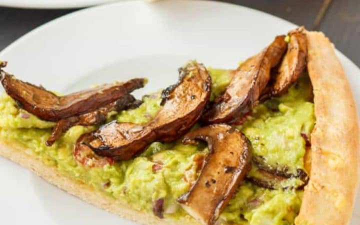 Vegan guacamole pizza on white plate