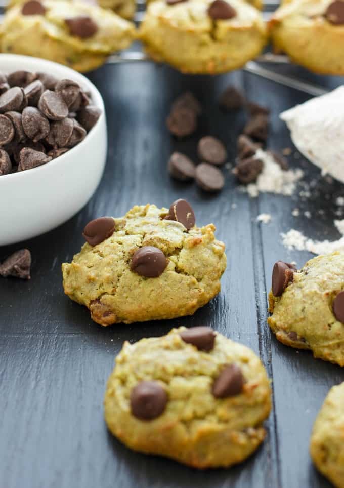 Avocado Chocolate Chip Cookies on black table with white bowl full of chocolate chips #healthy