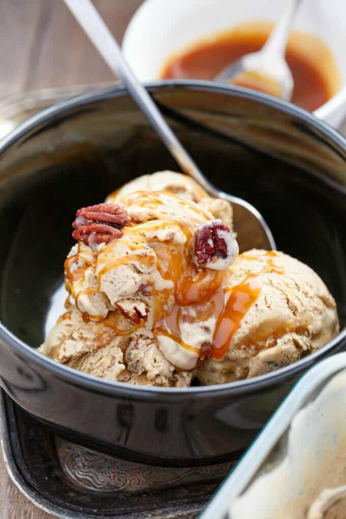 Coffee Ice Cream with Toasted Pecans and a Caramel Swirl  in black bowl with spoon