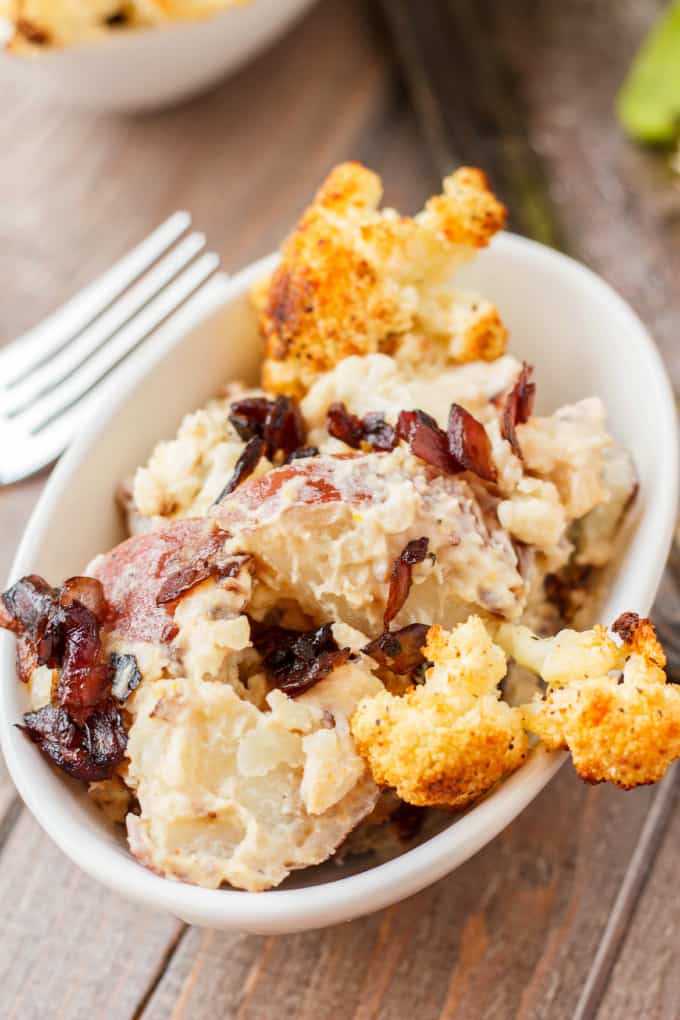 Potato Salad with Roasted Cauliflower and Caramelized Onions in white bowl on wooden table