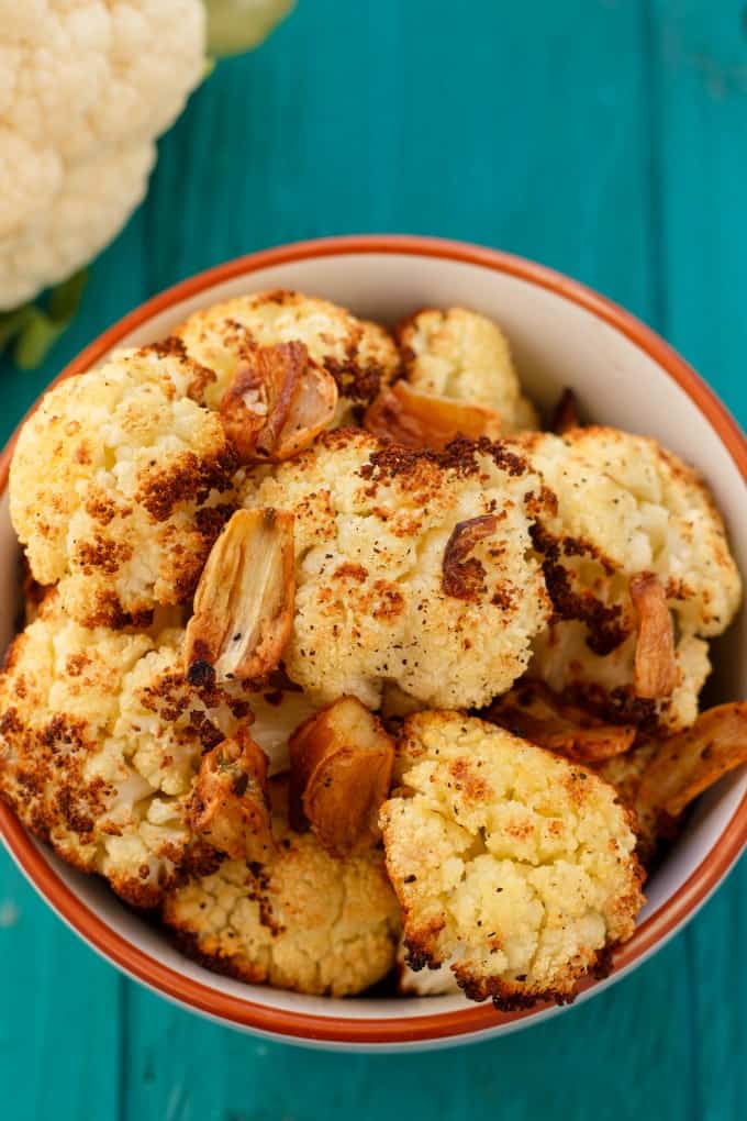 Roasted Cauliflower with Garlic in white bowl on blue table#glutenfree