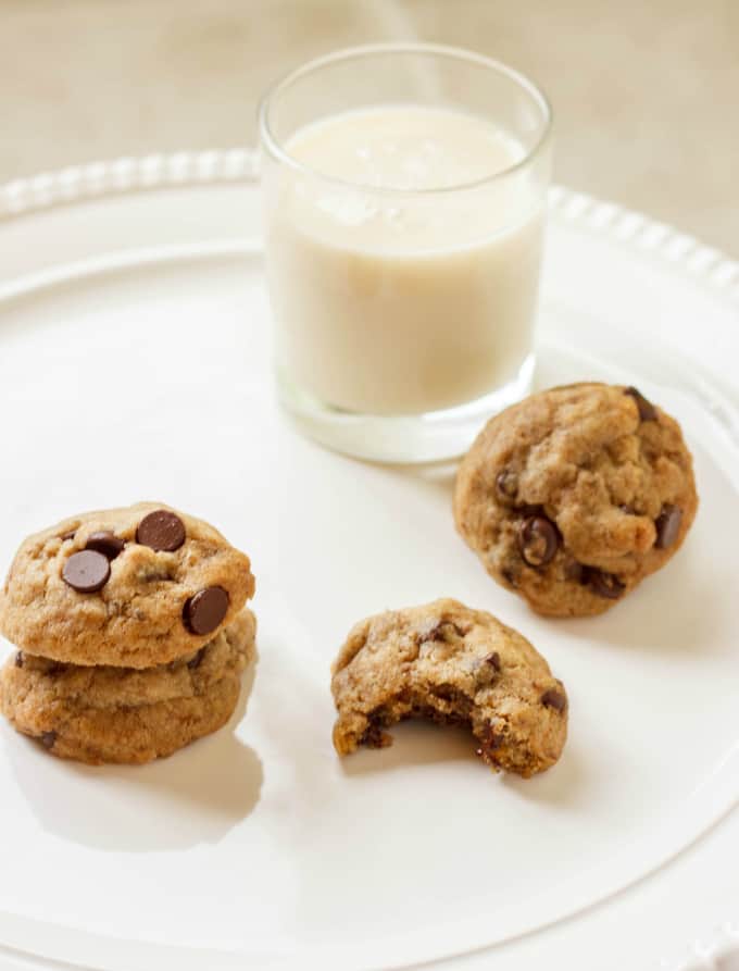 Vegan Chocolate Chip Cookies on white plate next to glass of milk