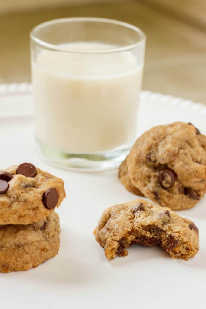 Vegan Chocolate Chip Cookies on white plate next to glass of milk