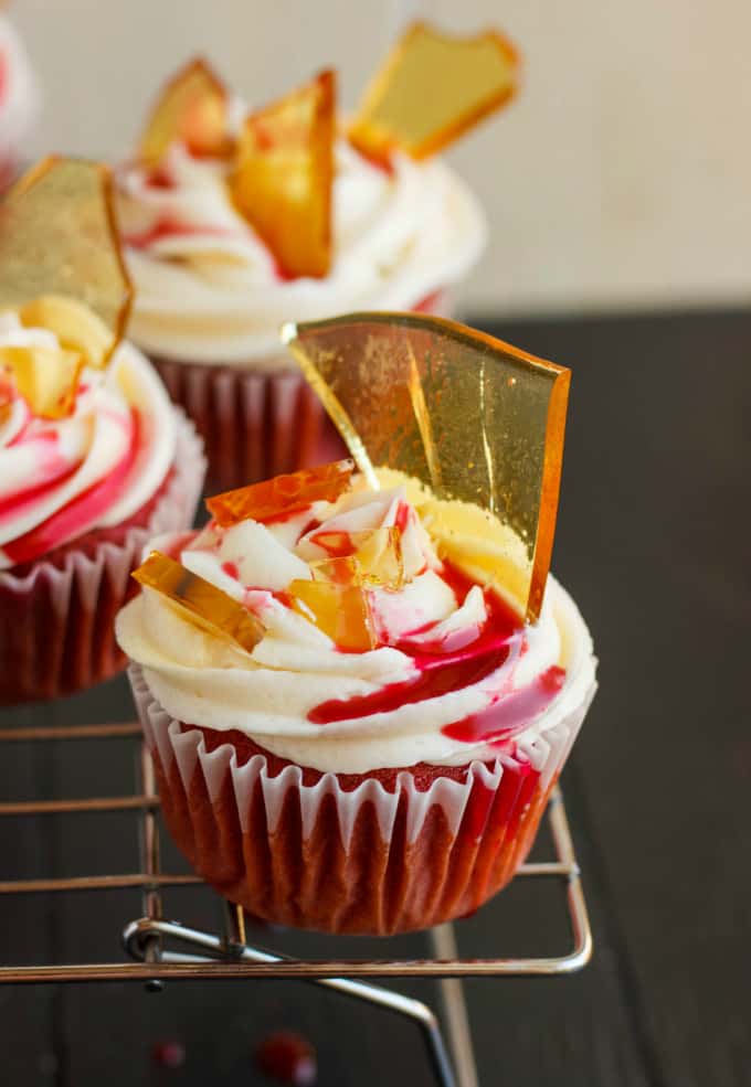 Halloween Cupcakes Blood Cupcakes with Broken Beer Bottle Glass Shards on baking rack on black table