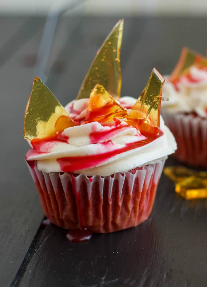 Halloween Cupcakes Blood Cupcakes with Broken Beer Bottle Glass Shards on black table with drops of syrup and glass shards