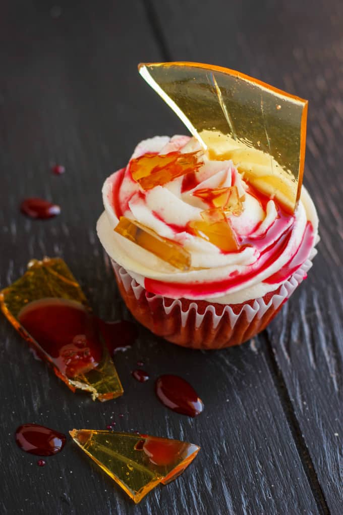 Halloween Cupcakes Blood Cupcake with Broken Beer Bottle Glass Shards on black table with drops of syrup and bottle shards