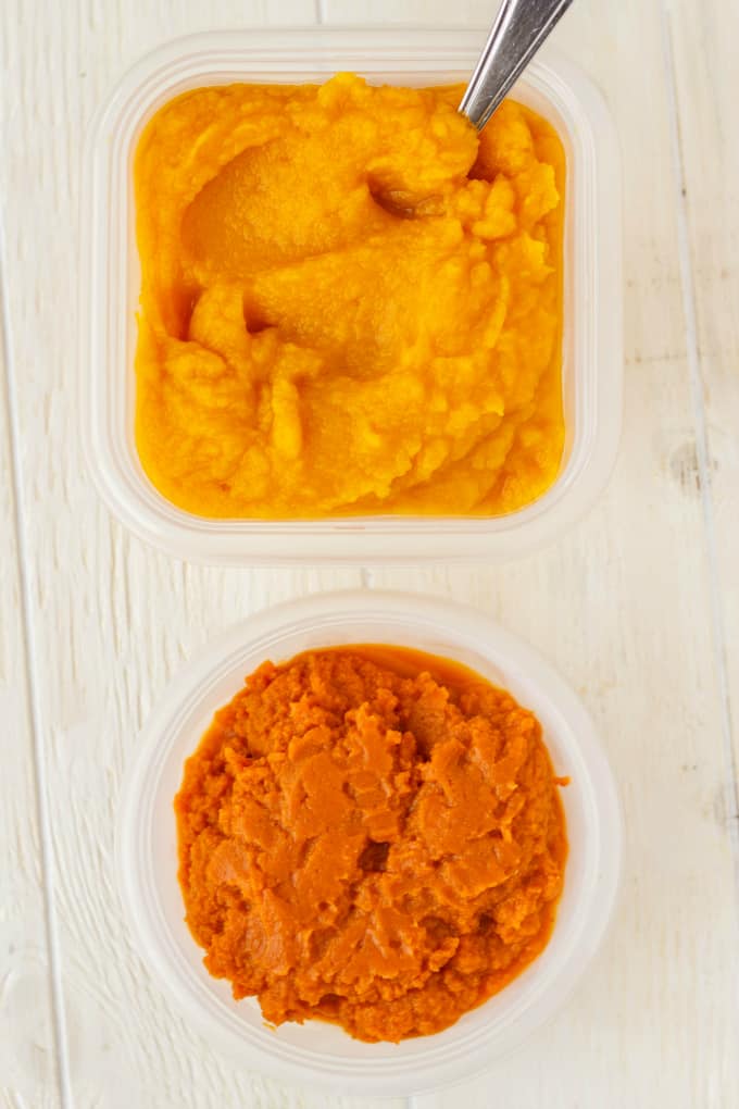 Homemade Pumpkin Puree in plastic containers with spoon on white table