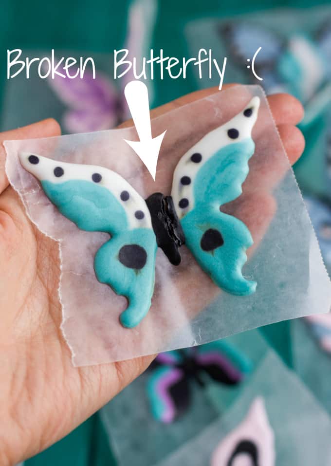 Royal Icing Butterflies held by hand on foil