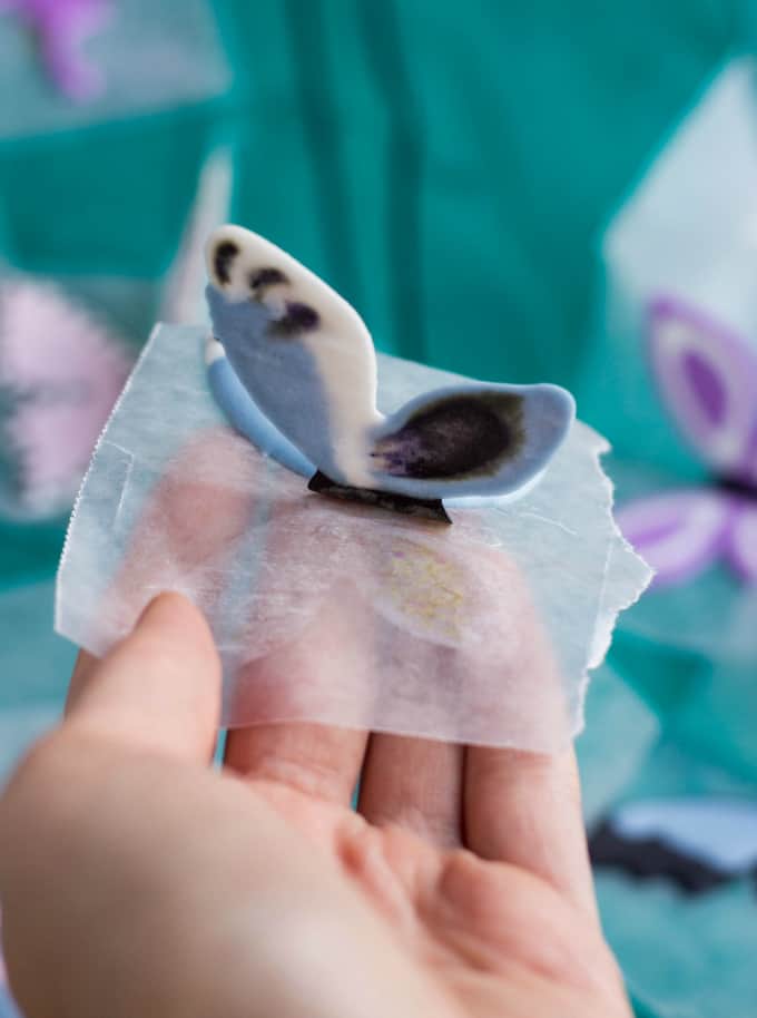 Royal Icing Butterflies held by hand on foil