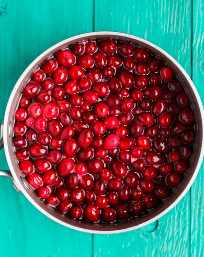 Pot full of cranberries on blue table