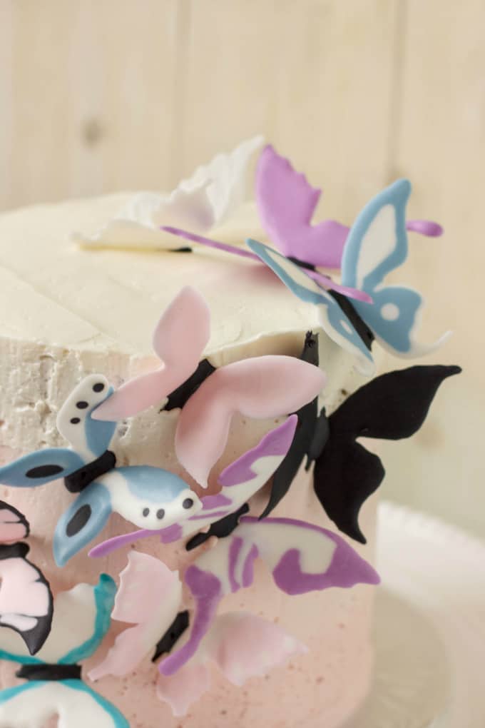 Pink Ombre Cake with Royal Icing Butterflies on white tray on white background