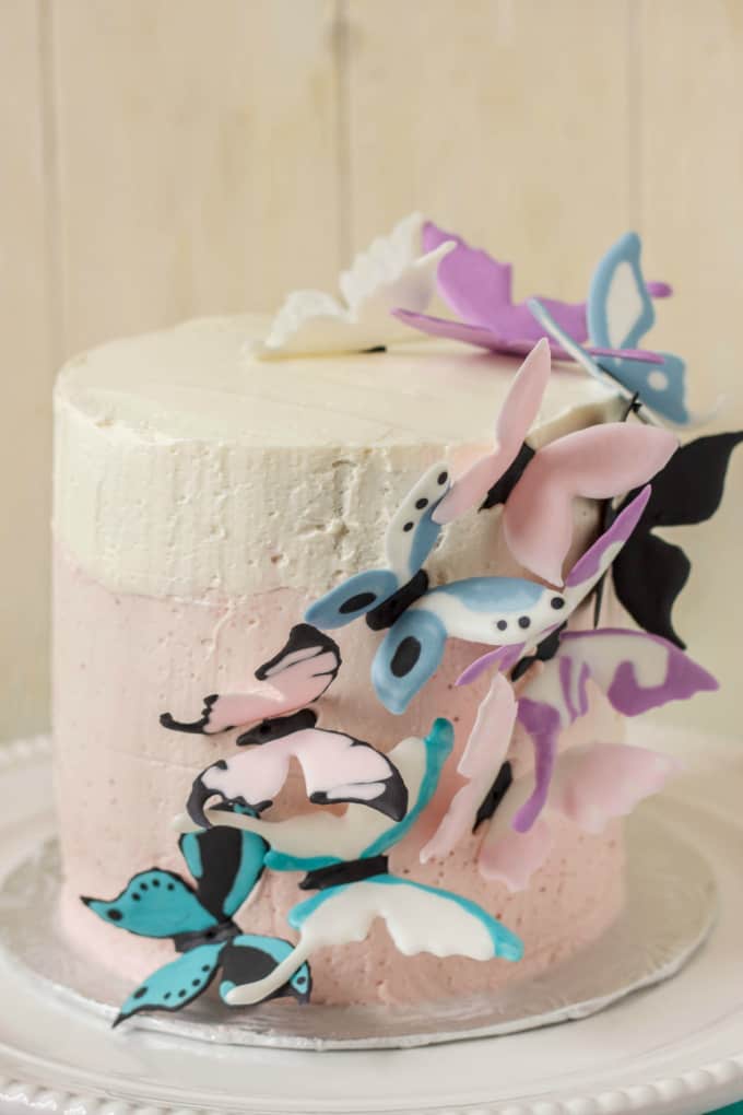 Pink Ombre Cake with Royal Icing Butterflies on white tray on white background