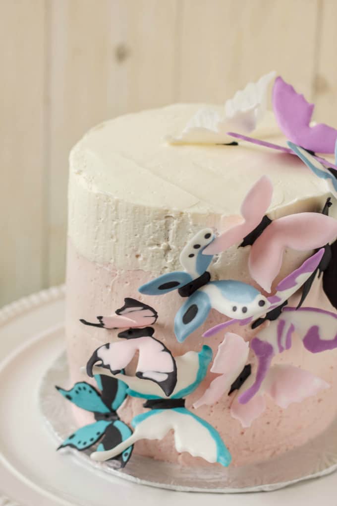 Pink Ombre Cake with Royal Icing Butterflies on white tray on white background