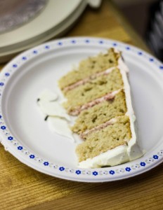 Slice of Pink Ombre Cake with Royal Icing Butterflies on white plate on brown table