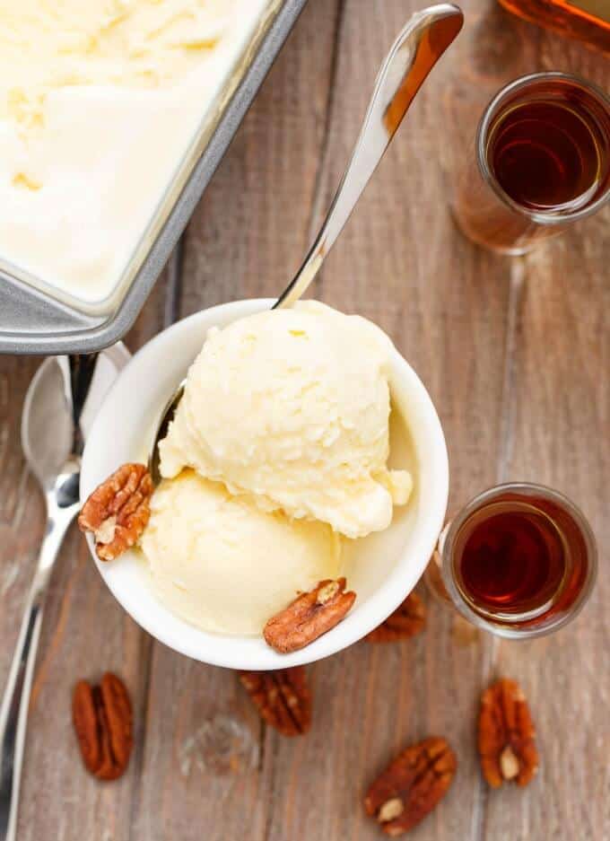 Amaretto Ice Cream in white bowl on wooden table with nuts, spoons and glass shots with amaretto liquor#dessert