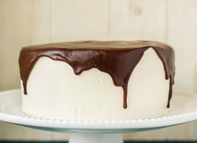 Chocolate Cake covered in Chocolate Ganache Glaze on white tray, white background
