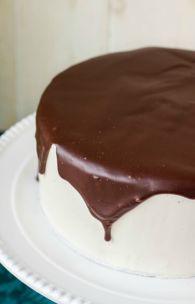 Chocolate Cake covered in Chocolate Ganache Glaze on white tray