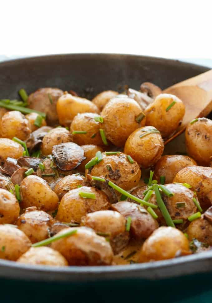 Roasted Baby Potatoes in a Homemade Mushroom Sauce in black pan with wooden spatula#potatoes