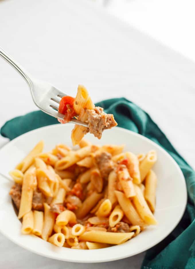 Sausage and Vodka Pasta Sauce with pasta on white plate picked by fork