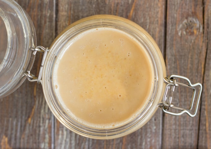 Toasted Coconut Butter in glass jar with lid on wooden table