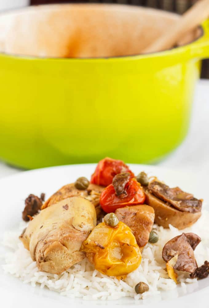 Artichoke Hearts and Mushrooms over Rice on white plate, green cooking pot in the background