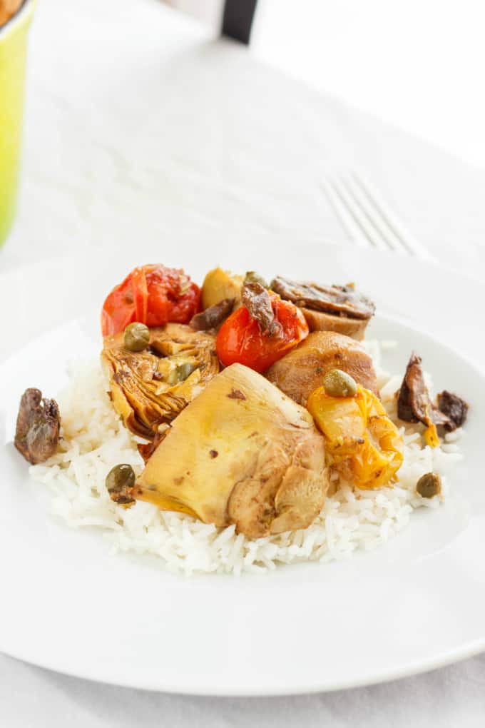 Artichoke Hearts and Mushrooms over Rice on white plate on white table