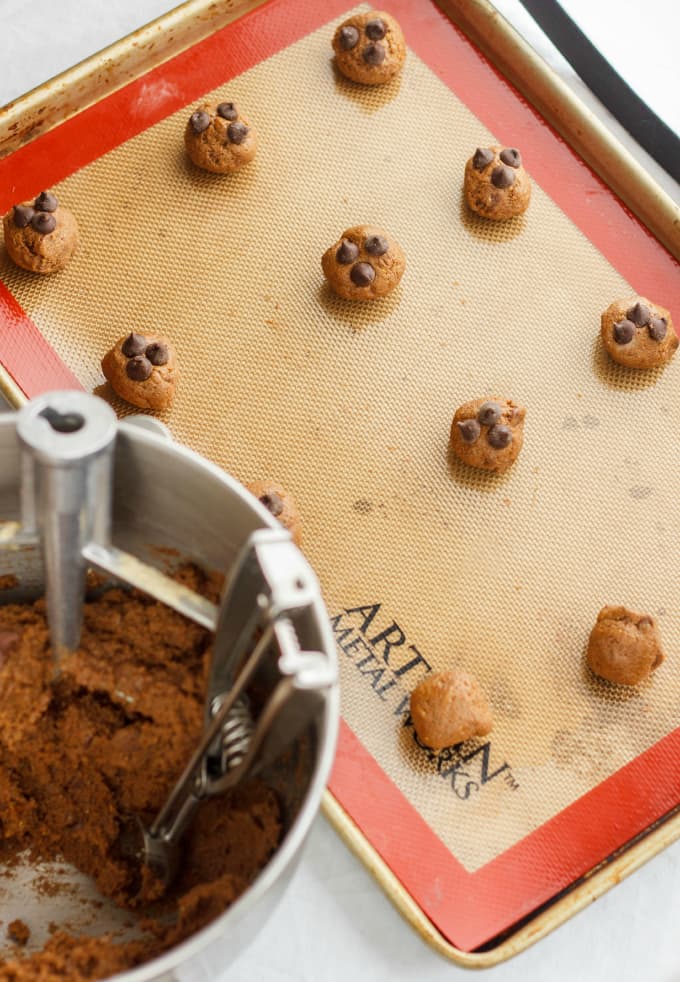 Chocolate Chip Cookies made with Lentil Flour on baking pot near mixer with cookie dough on white table