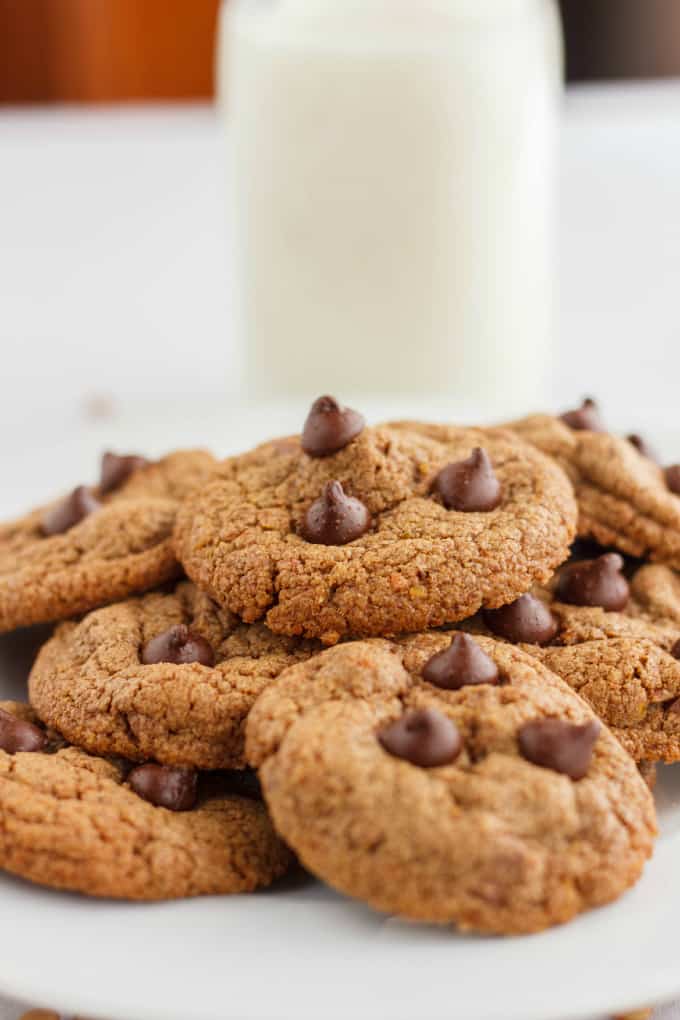 Chocolate Chip Cookies made with Lentil Flour on white plate, glass bottle of milk in the background